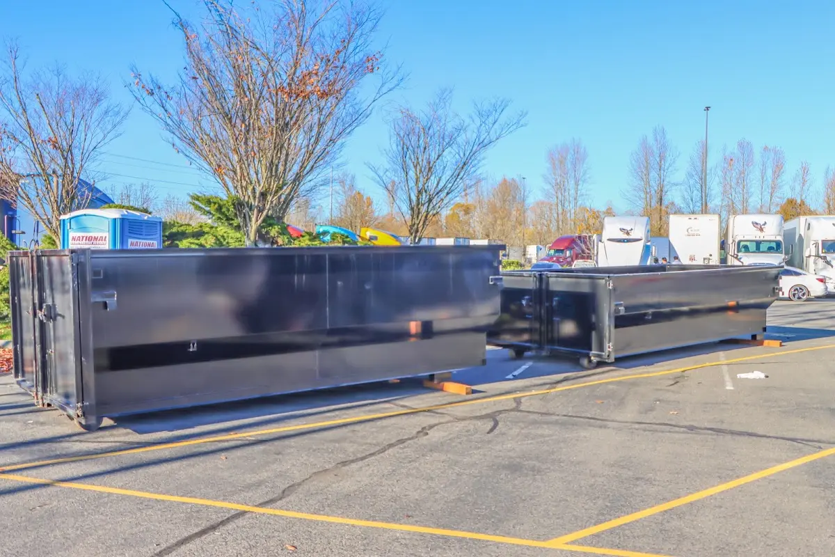 Professional dumpster rental service with roll-off container on residential driveway in Country Homes